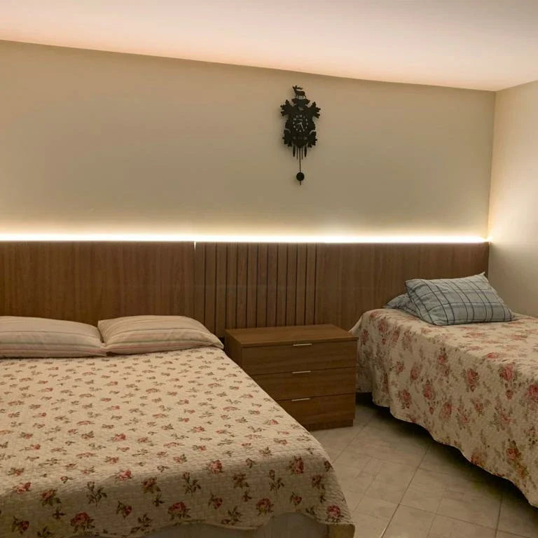 Dormitório planejado com cabeceira ripada em madeira e iluminação LED em Brasília - Fábrica Status